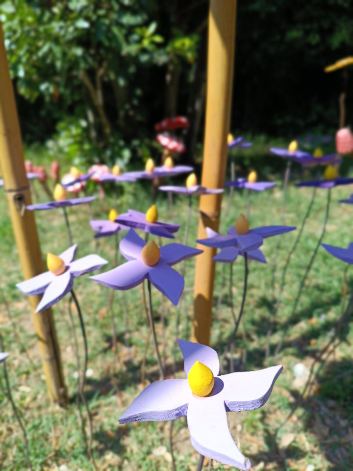 Fiore piccolo viola in legno fatto a mano – gruppo nel prato tra canne di bambù