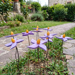 Fiore piccolo viola in legno fatto a mano – bordura lungo un vialetto in pietra